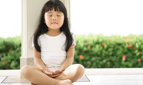 Una niña asiática meditando